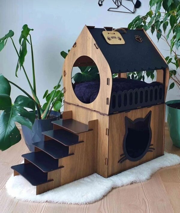 Maison pour chat en bois noir et marron avec escalier intégré et espace de couchage confortable.