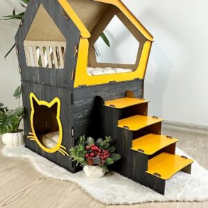 Maison pour chat en bois noir et jaune avec escalier intégré et espace de couchage confortable.
